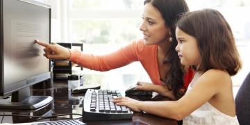 mother and daughter using the computer together